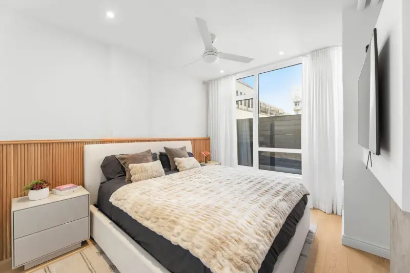 Bedroom with large windows and hardwood floors